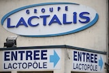An exterior image of a Lactalis factory with the company's logo on the wall and a sign pointing to the entrance.