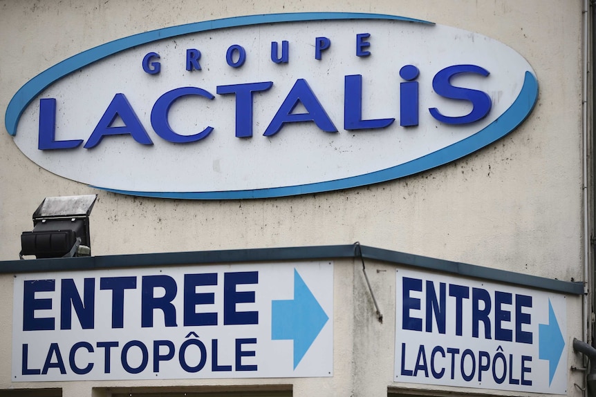 A exterior image of a Lactalis factory with the company's logo on the wall and a sign pointing to the entrance.
