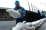 A worker uses sandbags to cover up power faults
