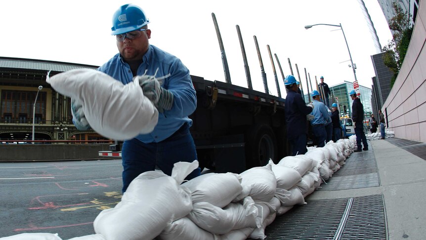 A worker uses sandbags to cover up power faults