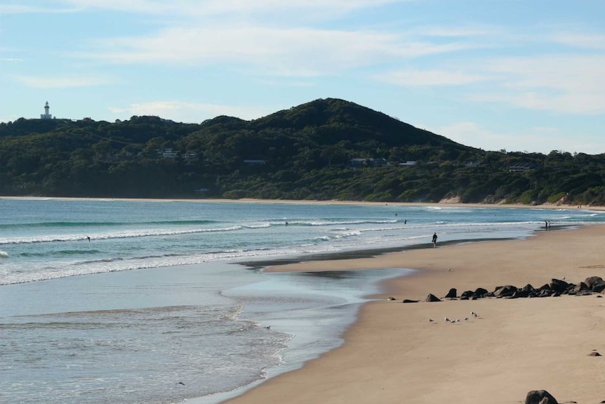 Looking along the sand at the Byron Bay Main Beach toward the famous lighthouse.