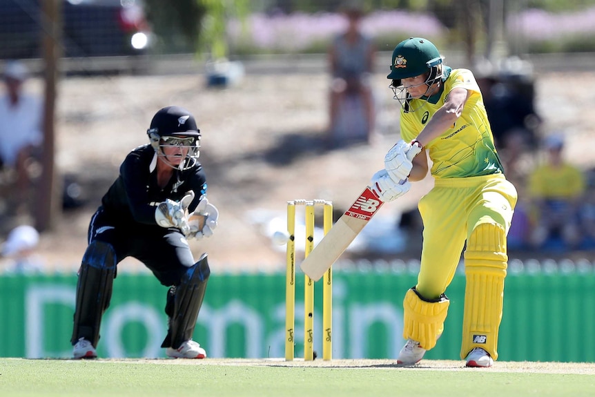 Meg Lanning plays a shot on the off side with her back leg bent, head over the ball