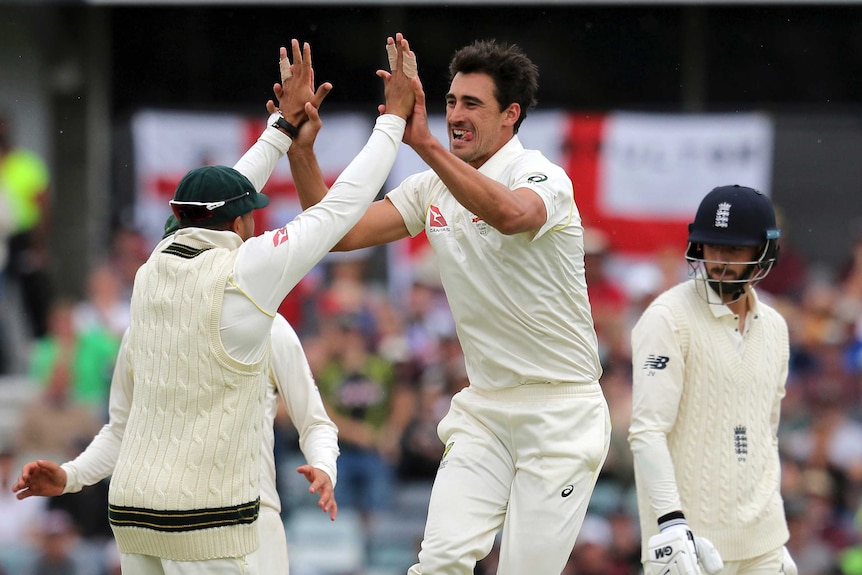 Mitchell Starc high fives a teammate as James Vince walks off.