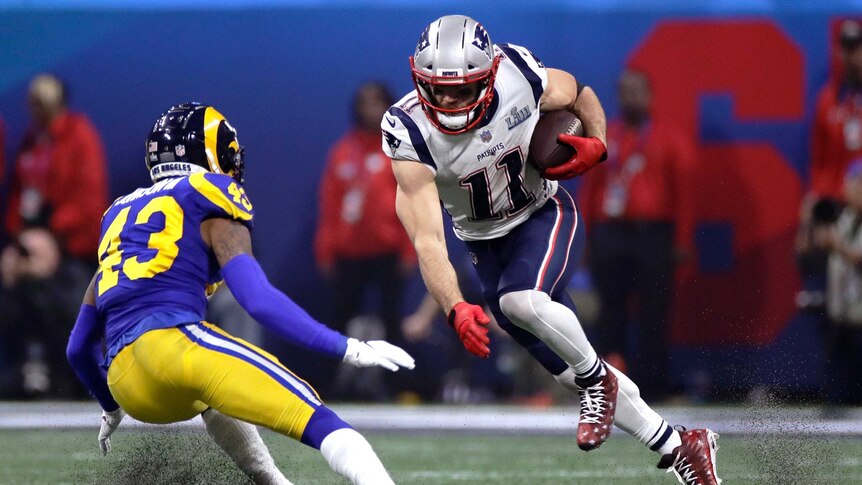 Julian Edelman steps off his right foot with the ball in his left hand as he attempts to beat the tackle of John Johnson III.