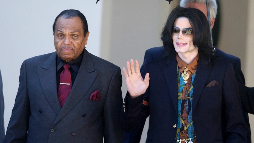 Joe Jackson with son Michael Jackson, who is waving and smiling