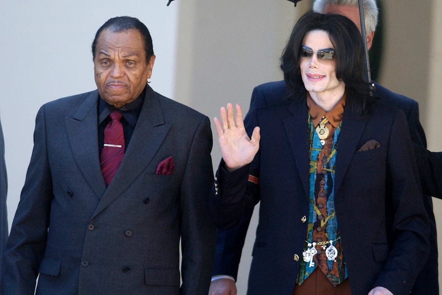 Joe Jackson with son Michael Jackson, who is waving and smiling