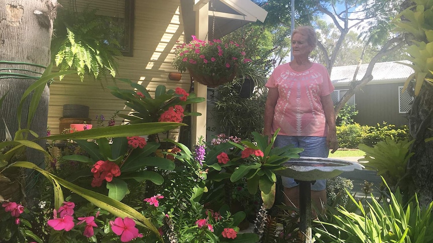Retiree 68-year-old Rosalie Collier stands looking at the garden she has planted next to her caravan.