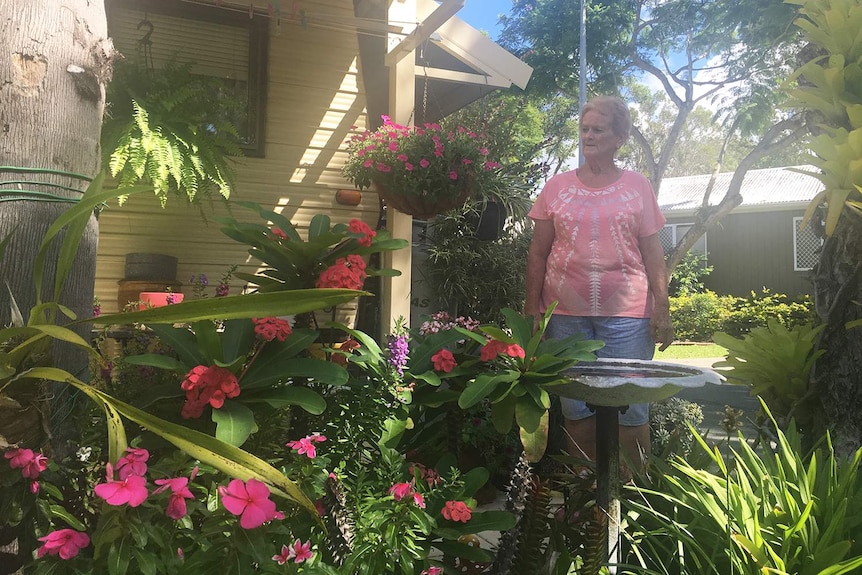 Retiree 68-year-old Rosalie Collier stands looking at the garden she has planted next to her caravan.