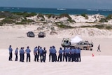 Vehicles and police surround a tent in Wedge Island sand dunes where 20-year-old man was found stabbed to death.