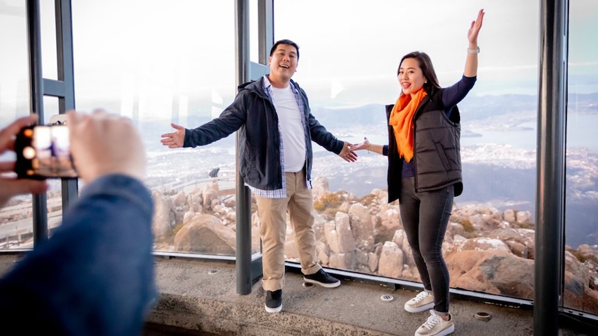 Asian tourists pose for photo at Mt Wellington summit viewing shelter, photo from Tourism Australia.