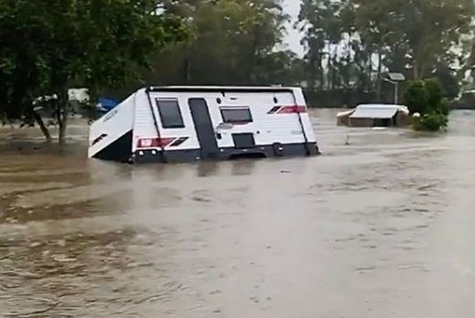 A caravan half-submerged in floodwaters
