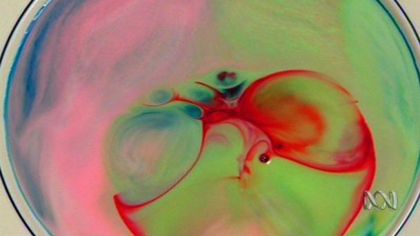 Coloured liquid swirls on surface