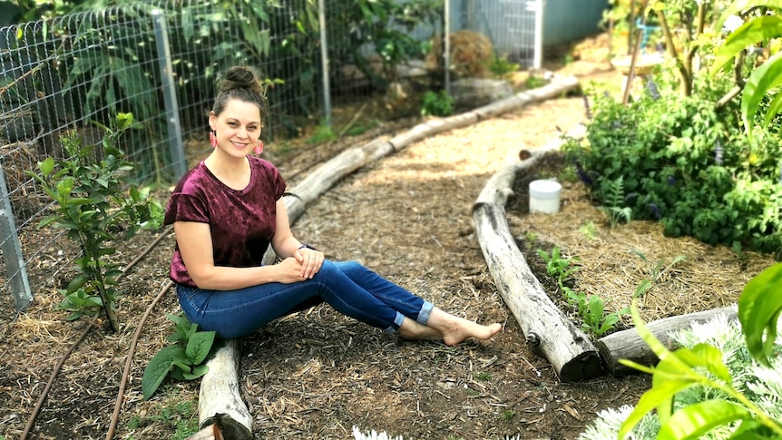 Koren sits beside her green manure garden
