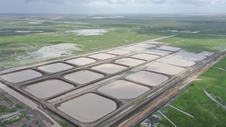 an aerial view of prawn ponds filled with water.