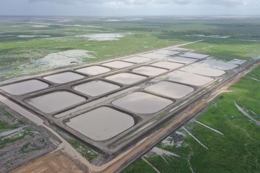 an aerial view of prawn ponds filled with water.