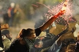 A protester holds a bottle of sparkler as protester shelter from police during a protest in Kenosha, Wisconsin.