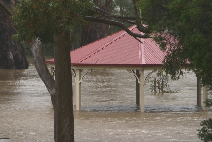 A gazebo deep under water in a park.