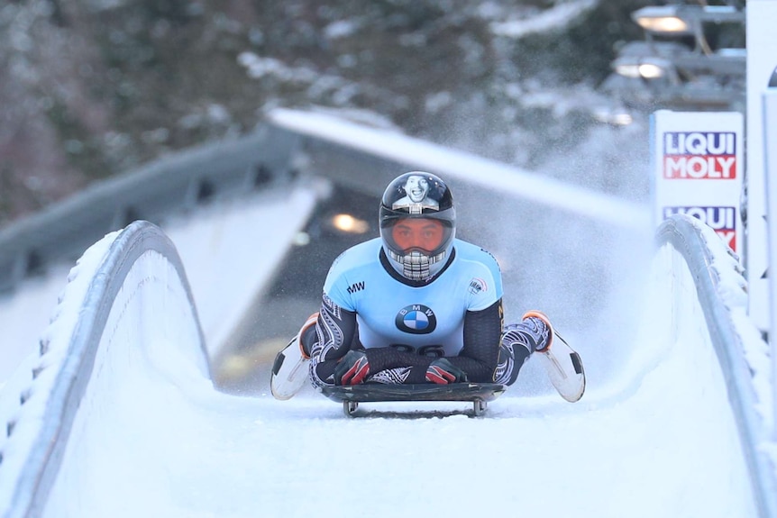 Nathan Crumpton slows down on his sled at the end of a run down the ice.