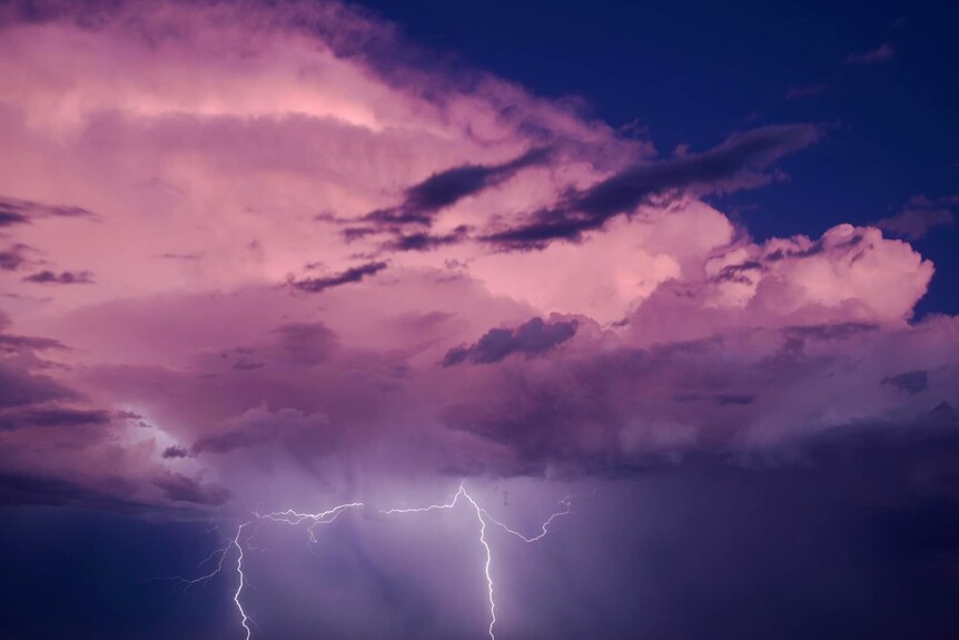 Purple hues on clouds with lightning.