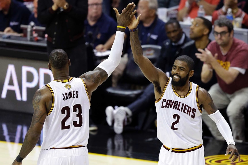 Cleveland Cavaliers' LeBron James (23) and Kyrie Irving (2) high five during second half of game three of NBA finals.