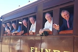 MPs look from the windows of a rail carriage