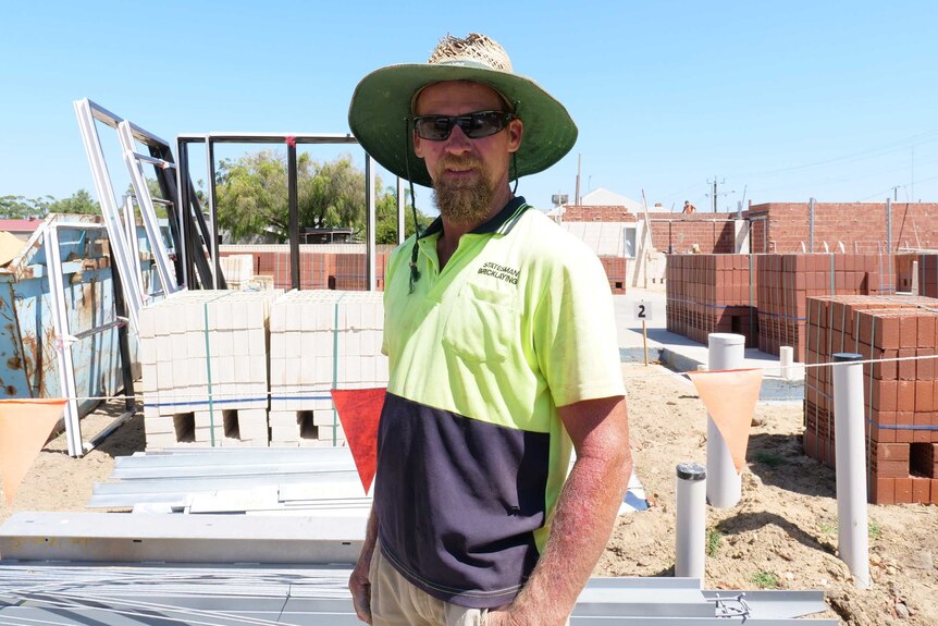 Bricklayer Jason Gobby stands in a construction site.