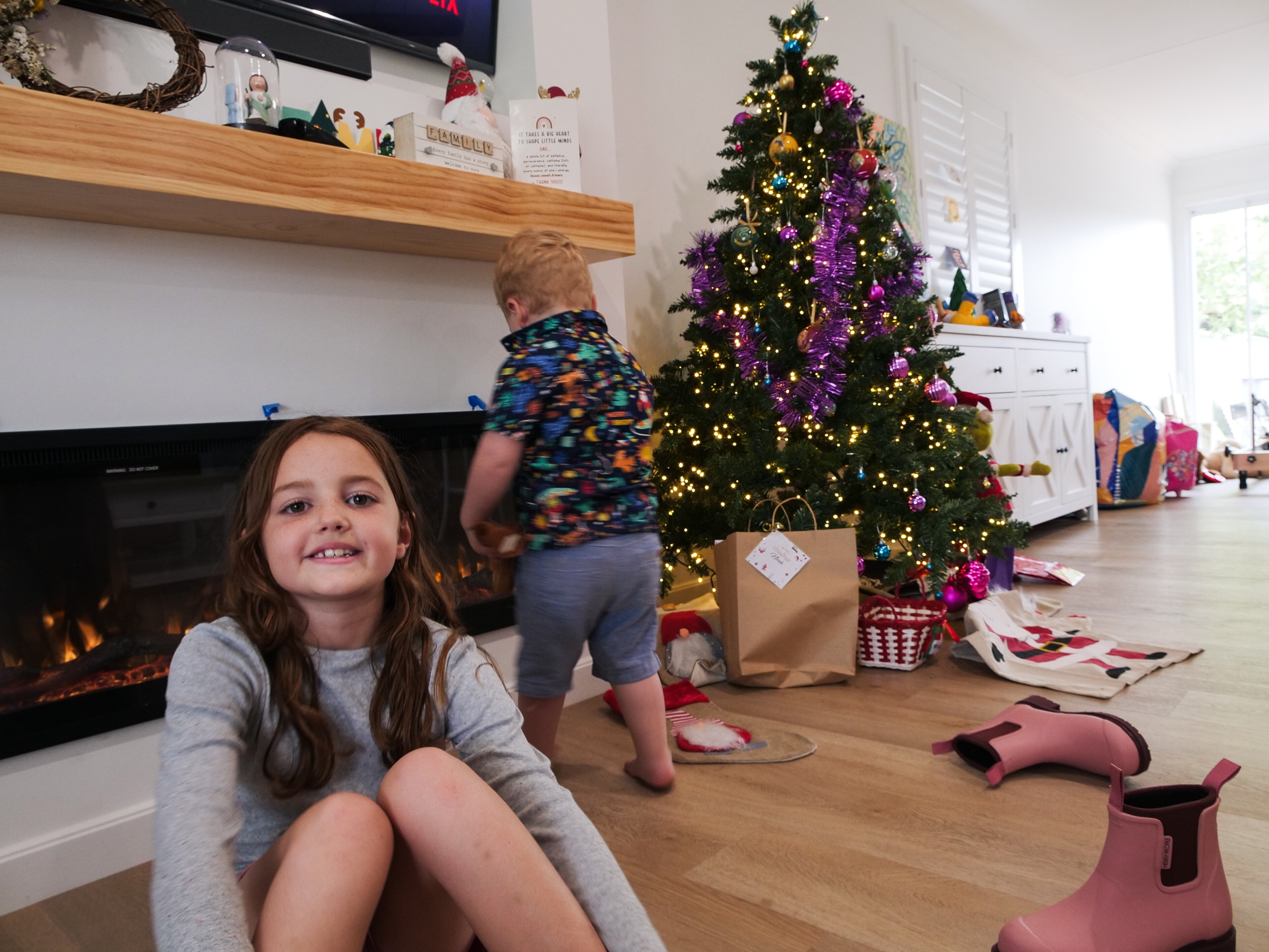 Family in home with Christmas tree up, new kitchen, new dark grey paint around fixed up house with Christmas decorations