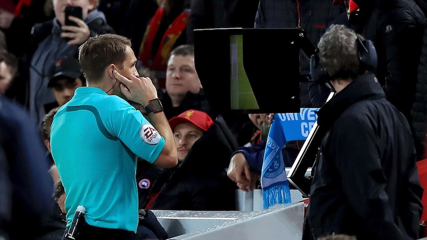 Match referee Craig Pawson uses the Video Assistant Referee to give a penalty to Liverpool.