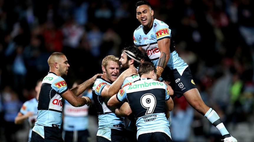 Cronulla NRL players embrace as they celebrate beating St George Illawarra.