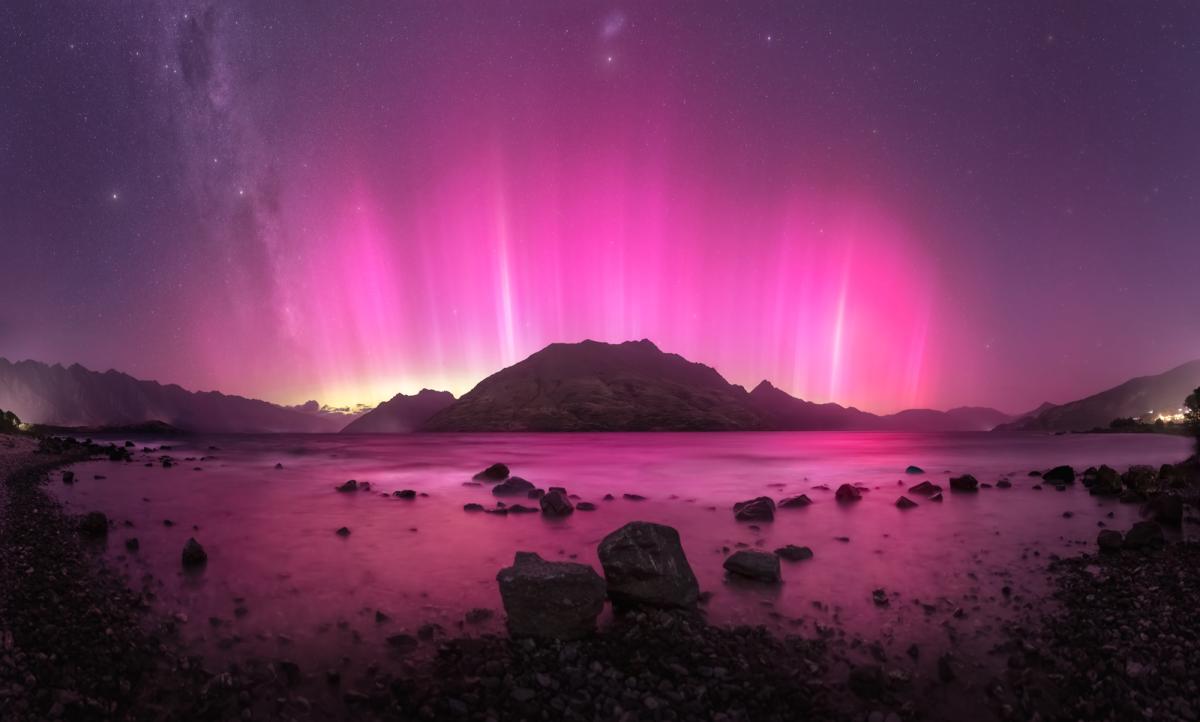 Panoramic image capturing an aurora with a rare pink and red hue over NZ