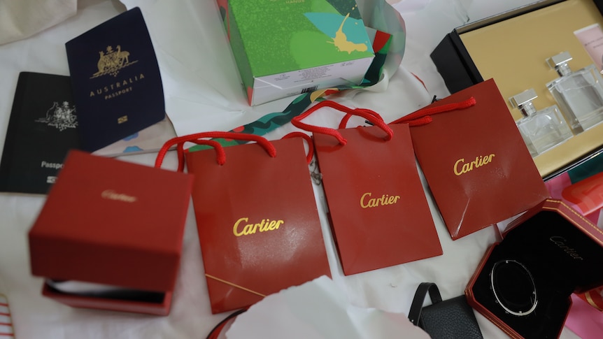 Red Cartier bags, passports and perfume bottles
