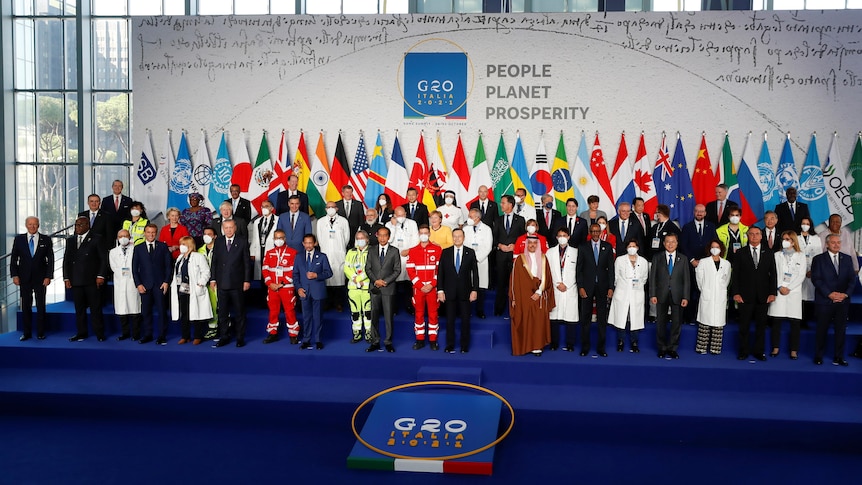 About 50 G20 state leaders in formal wear pose for a photo at the start of the G20 summit in Rome.