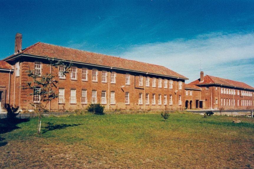 A large brown brick building with different wings.