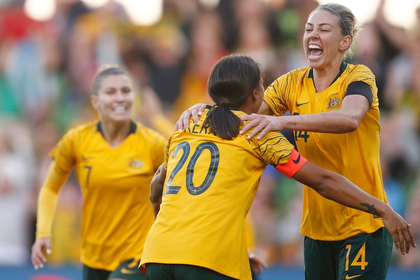Alanna Kennedy jumps into the arms of Sam Kerr