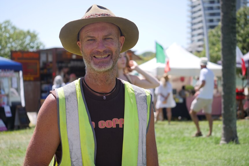 A man smiling in hat with hi vis shirt