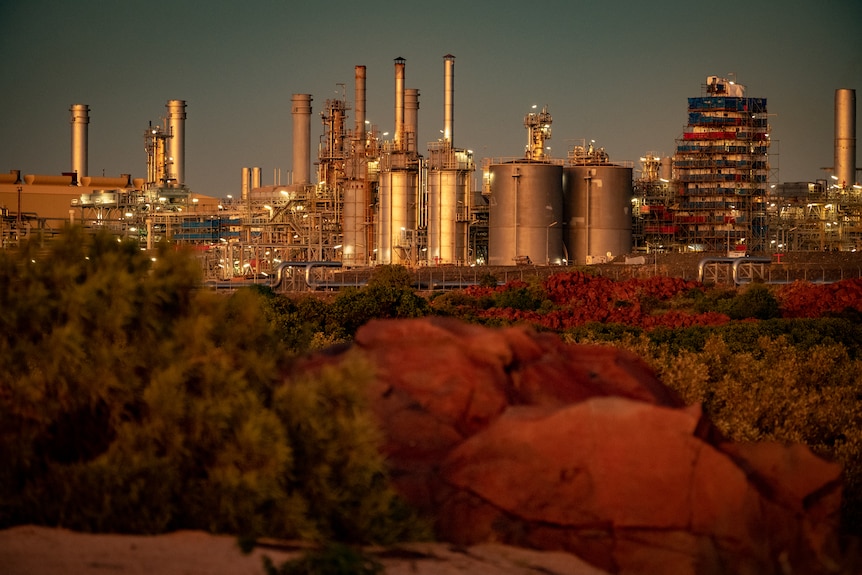 A distant shot of a gas plant at sunset