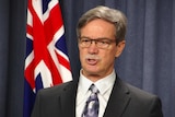 Close-up of WA Treasurer Mike Nahan in front of Australian flag.