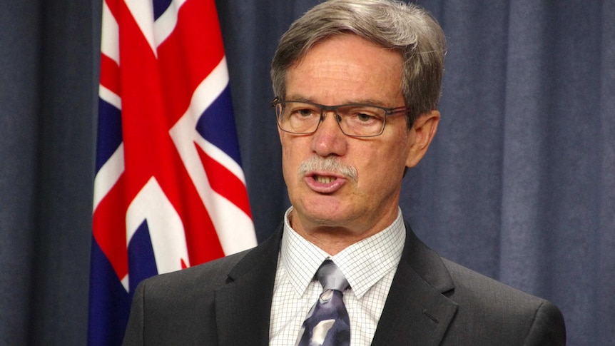 Close-up of WA Treasurer Mike Nahan in front of Australian flag.