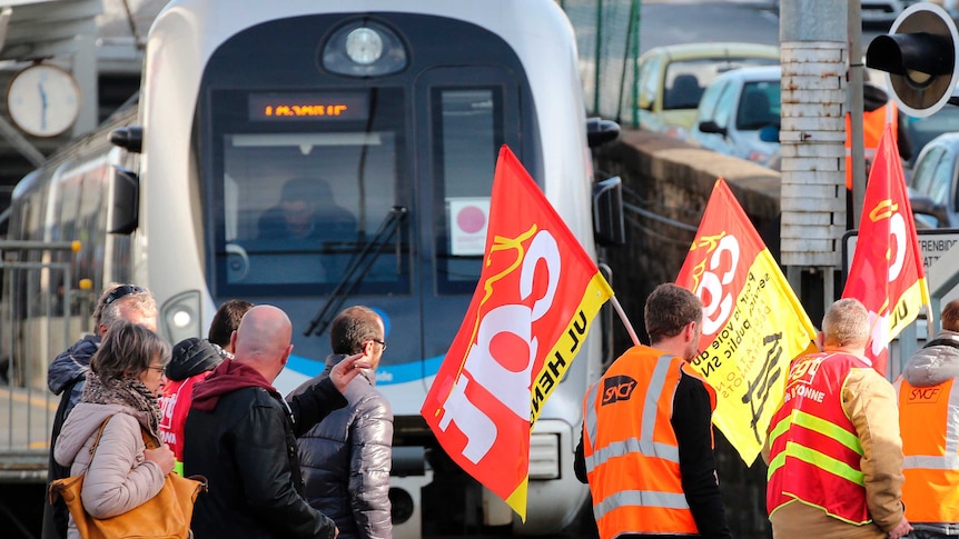 Rail workers of CGT union demonstrate in front of parked trains.