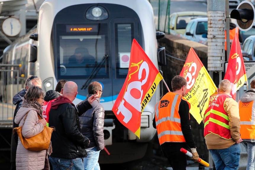 Rail workers of CGT union demonstrate in front of parked trains.