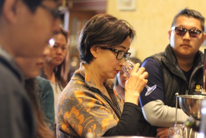 A group of people tasting wine