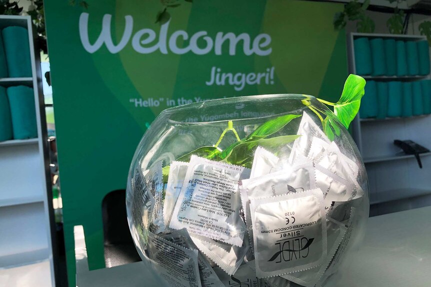 A bowl of condoms at the Commonwealth Games Athlete's Village in front of a sign saying 'Welcome'.