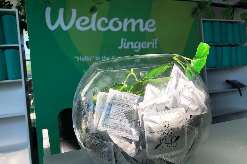 A bowl of condoms at the Commonwealth Games Athlete's Village in front of a sign saying 'Welcome'.