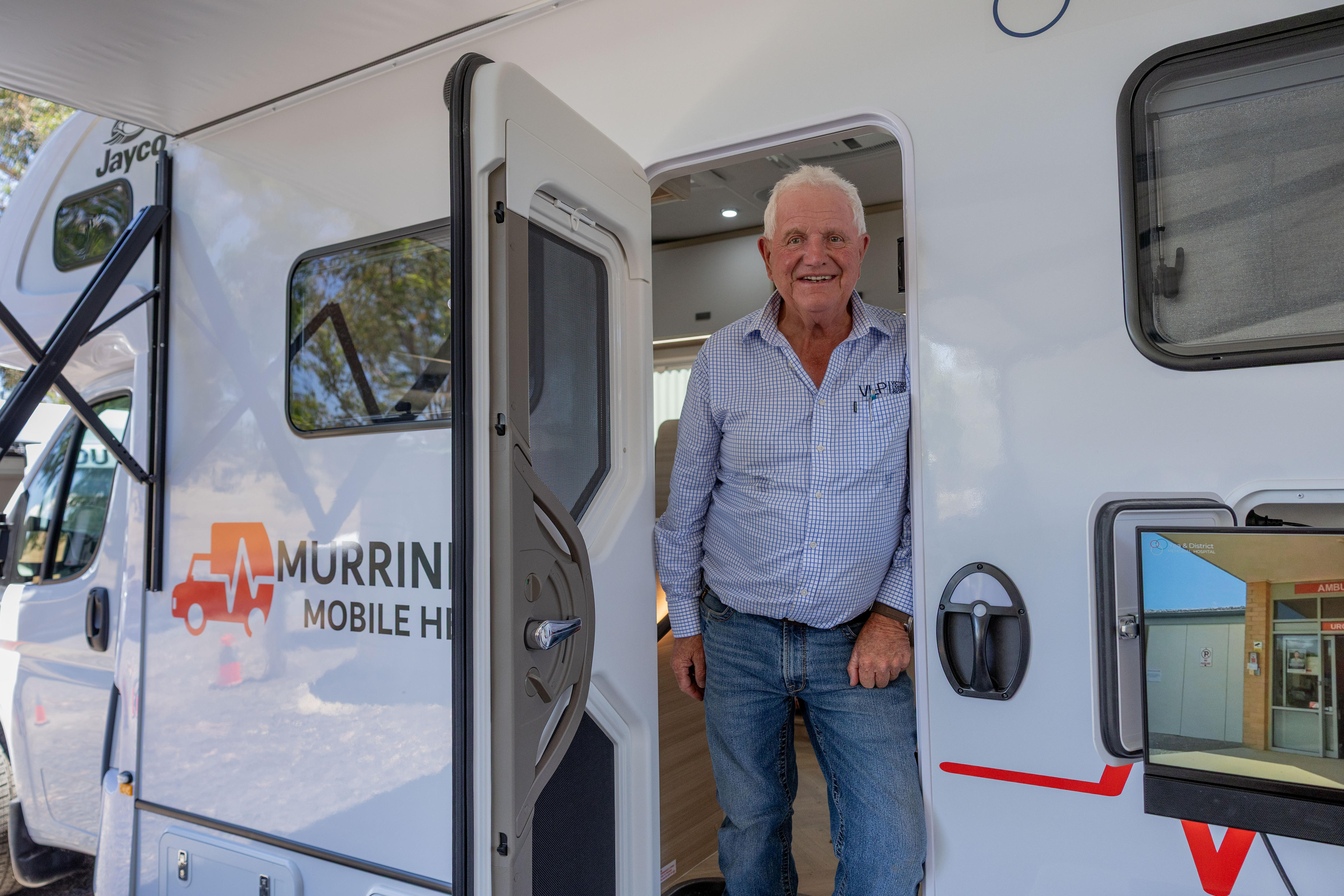 Un hombre se encuentra en la puerta de una casa móvil. 