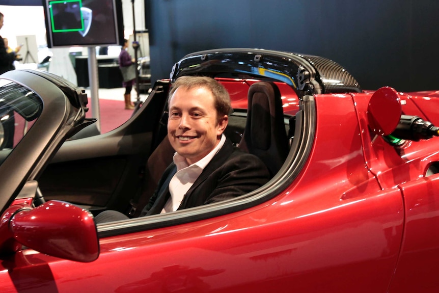 Elon Musk sits in the Tesla Roadster electric vehicle in 2009.