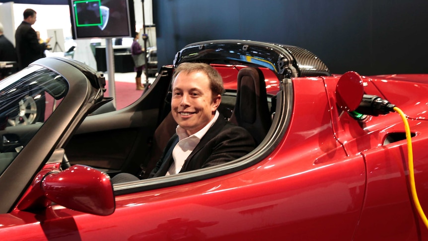 Elon Musk sits in the Tesla Roadster electric vehicle in 2009.