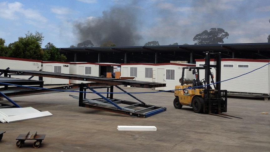 Black smoke rises from a fire at an industrial site at Narangba.