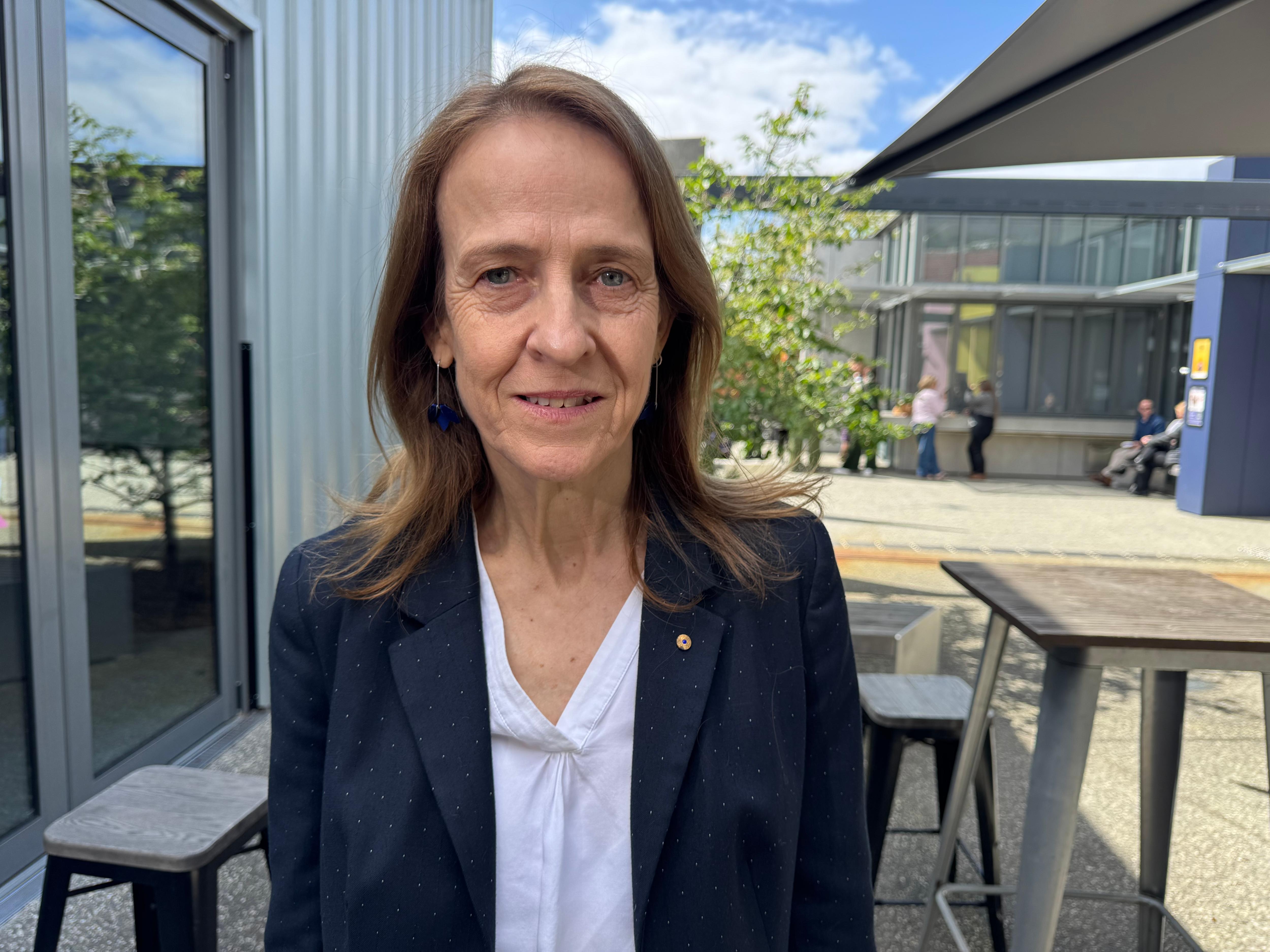 A woman with brown hair in a suit