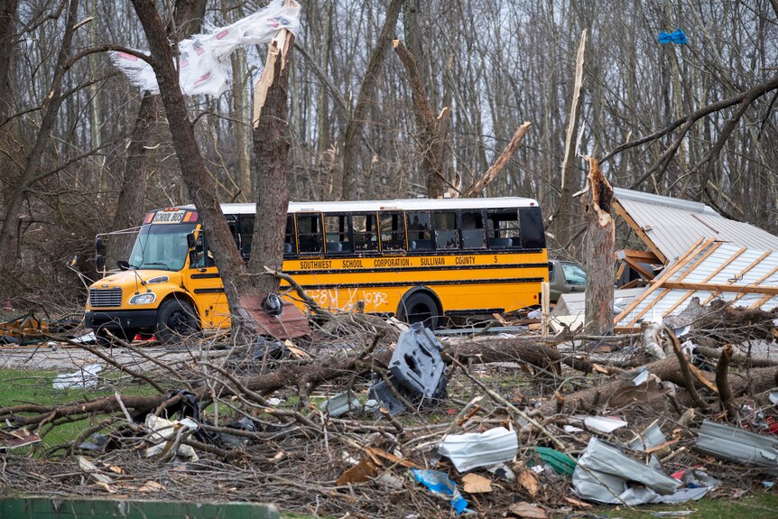 A yellow school bus surrounded by debris.
