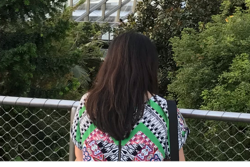 A woman stands in a garden.